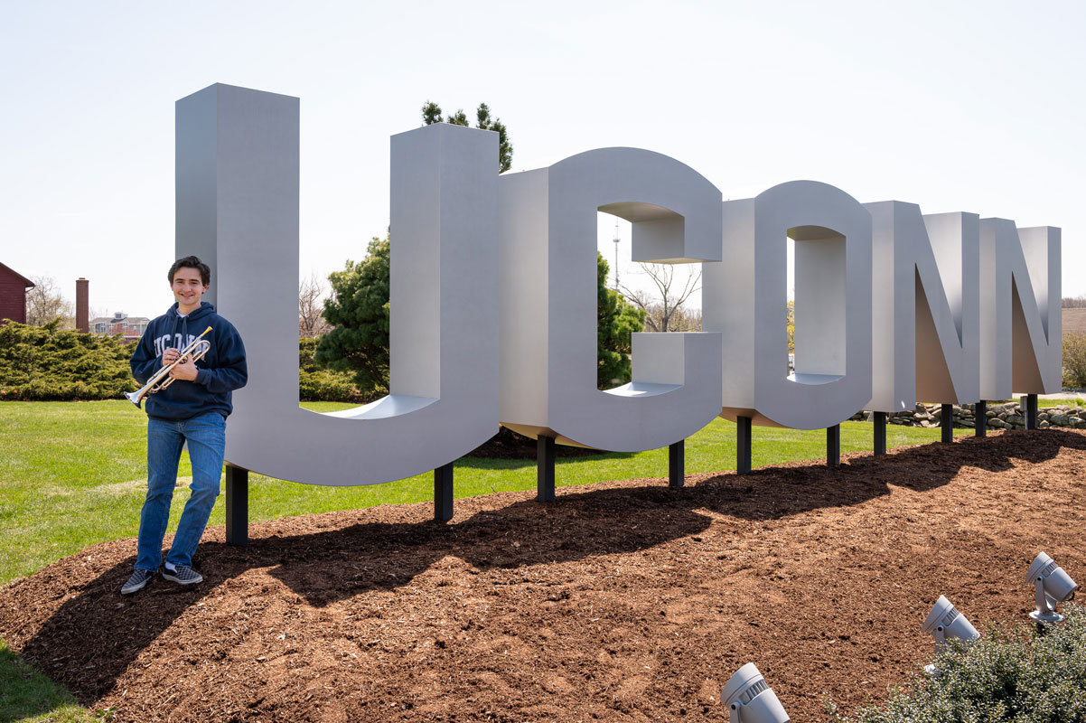 Michael Reed stands near the University of Connecticut's iconic sign. (Darin Reed photo.)