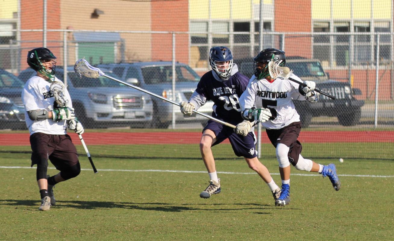 Michael Wright (center in blue) plays defense for Huntington. (Erik Krisch photo.)