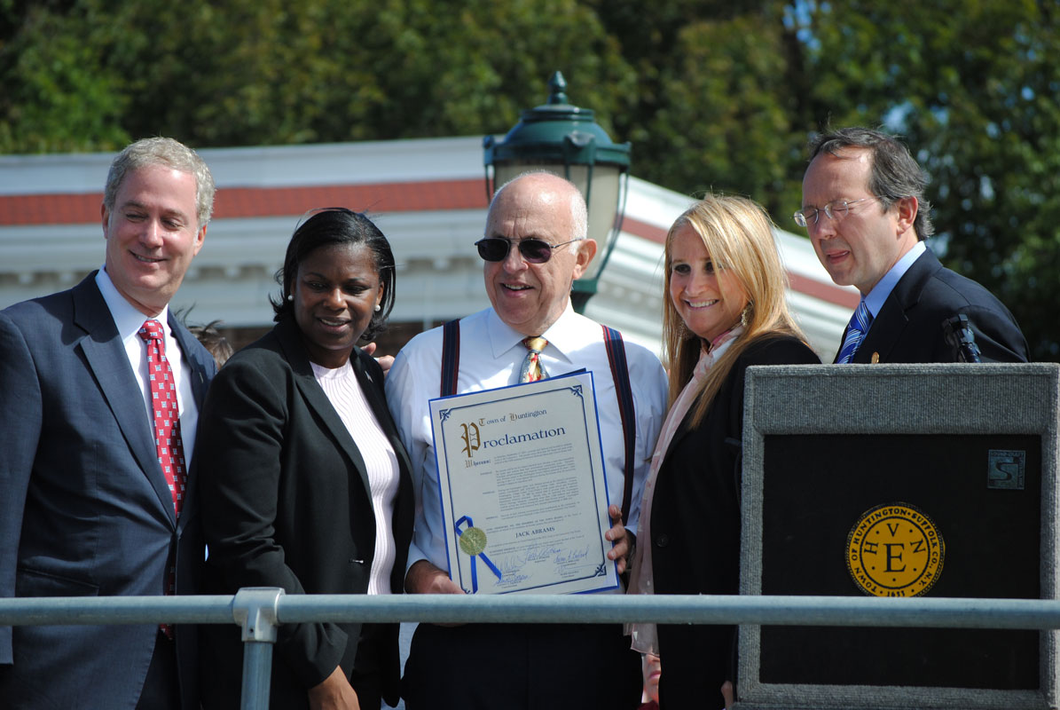 Elected officials gather around Jack Abrams, who holds a proclamation honoring him as grand marshal of the Awareness Day parade.