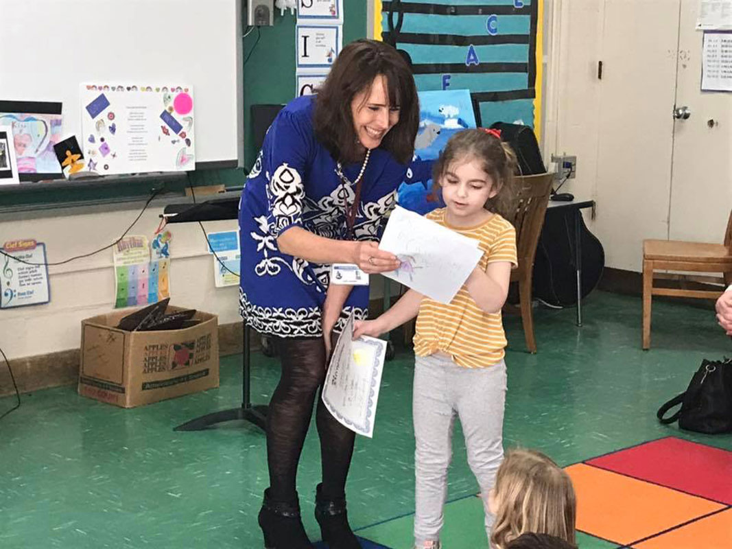 Flower Hill Principal Lucia Laguarda with students who showed off their pieces of art