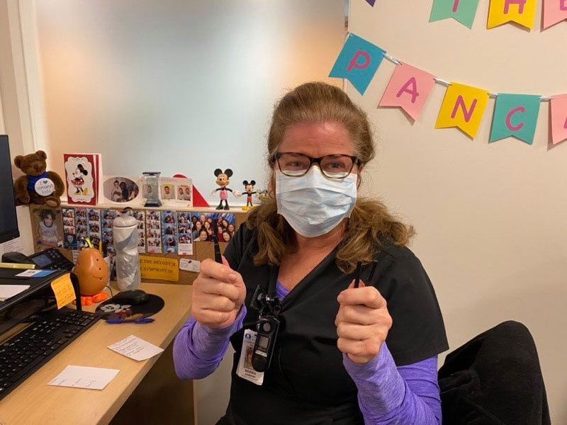 A frontline nurse wears a mask attached to Ronnie Carrillo ear-saving device.