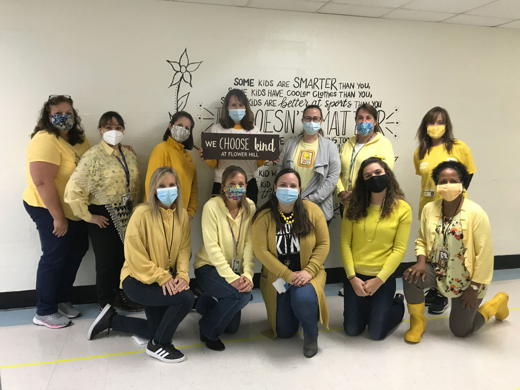 Flower Hill School Principal Lucia Laguarda (center) and staff wore yellow to commemorate World Kindness Day.