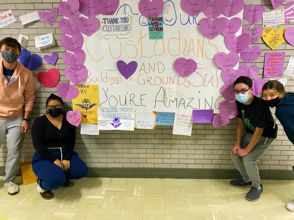 Natural Helpers executive board members near the bulletin board they created to recognize buildings and grounds staff.