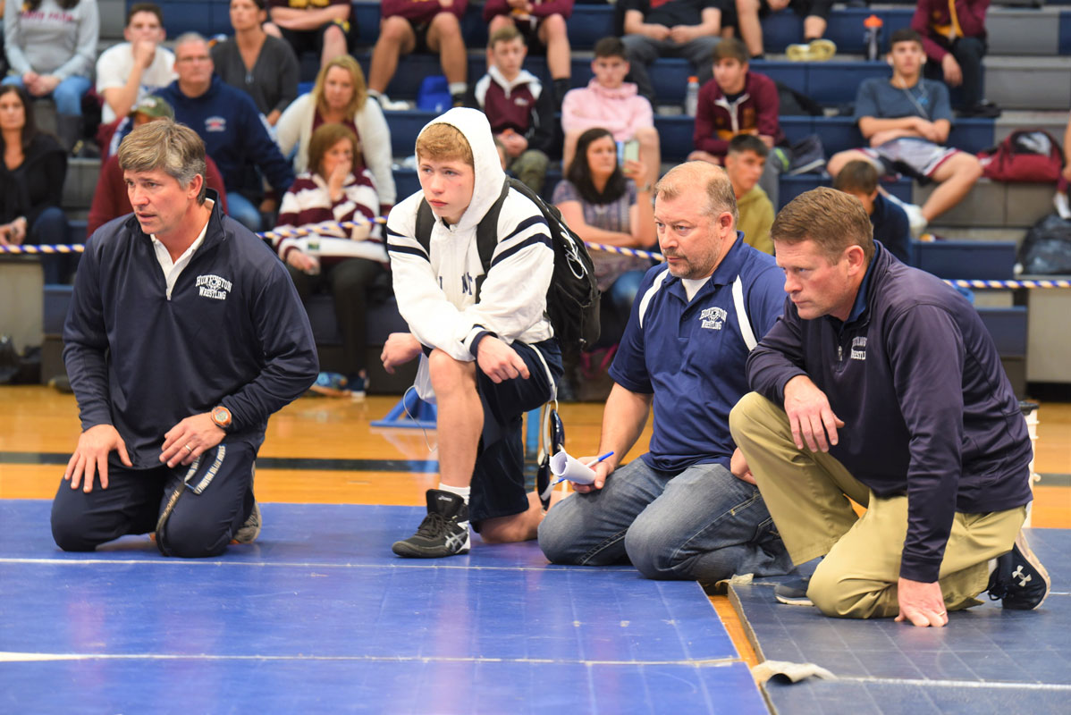 Christian St. John in the corner with the Blue Devil coaches