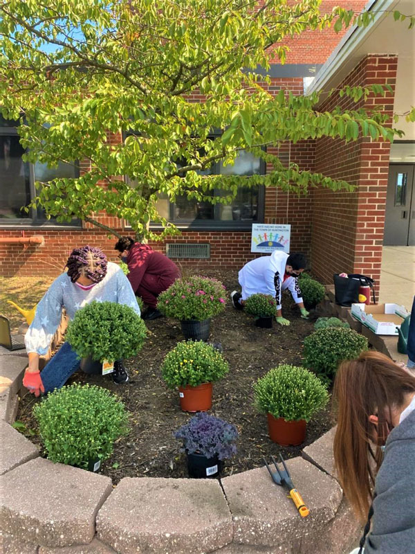 The students helped insure it will be a colorful fall outside the high school.