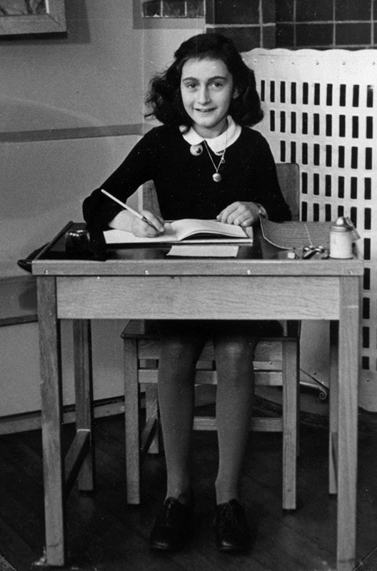 Anne Frank at her school desk in the Netherlands.