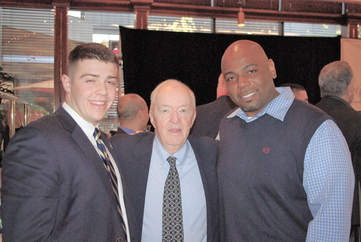 Former Huntington football coach Joe Lucey is flanked by Ron Wilson (right) and senior Brandon Fiordelisi in December 2010.