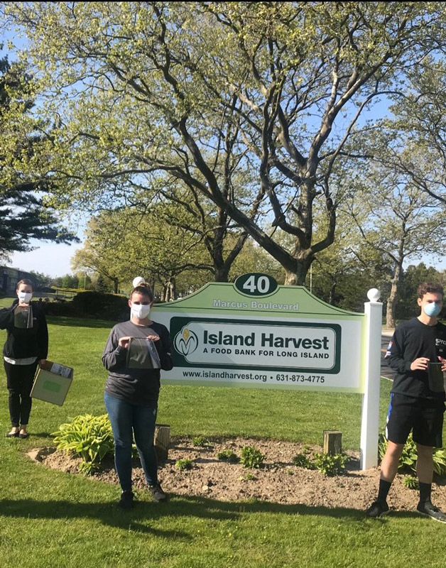 Alex Frawley (right) at Island Harvest with his face shields.