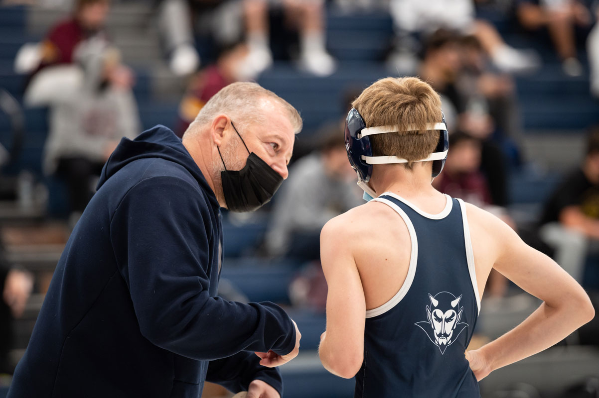 Assistant coach Jamie St. John gives advice to lightweight Walter Kusterbeck. (Darin Reed photo.)