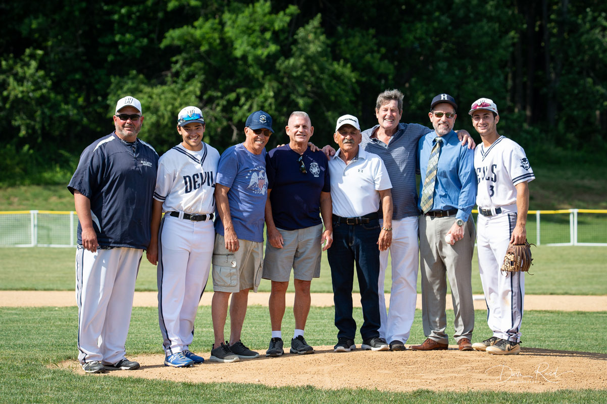 Current and former coaches, 1965 team members, 2021 captains and Supt. Jim Polansky on the mound before the game. (Darin Reed photo.)