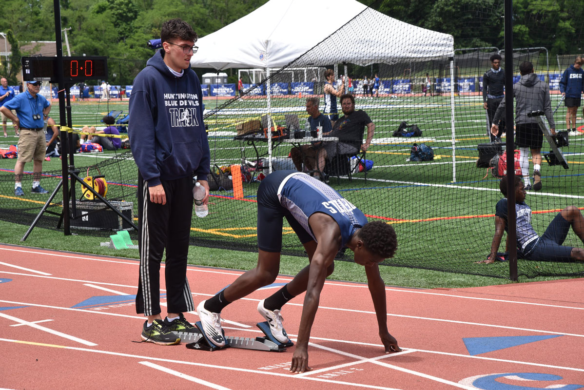 Quincy Chery gets set in the blocks as CJ Kiviat holds them steady.