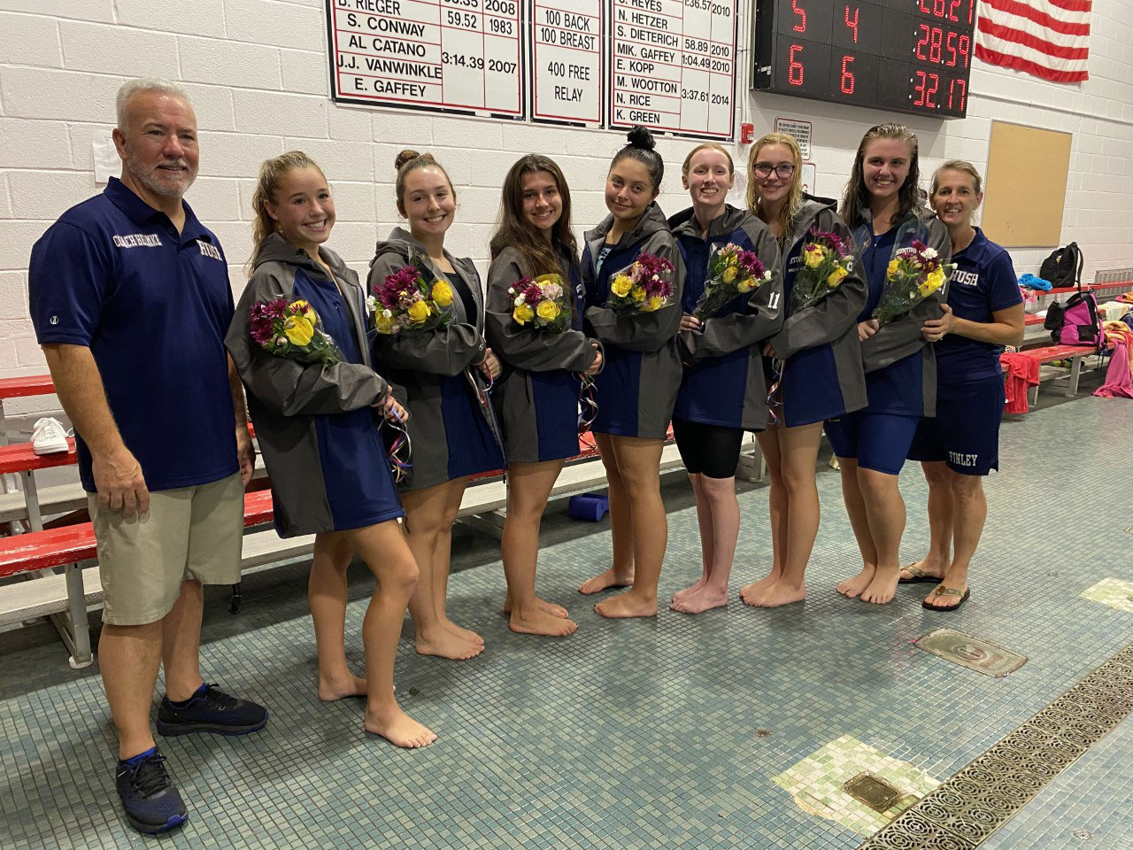 Huntington's seven seniors are flanked by coaches Chris Helmke and Meg McConnell.