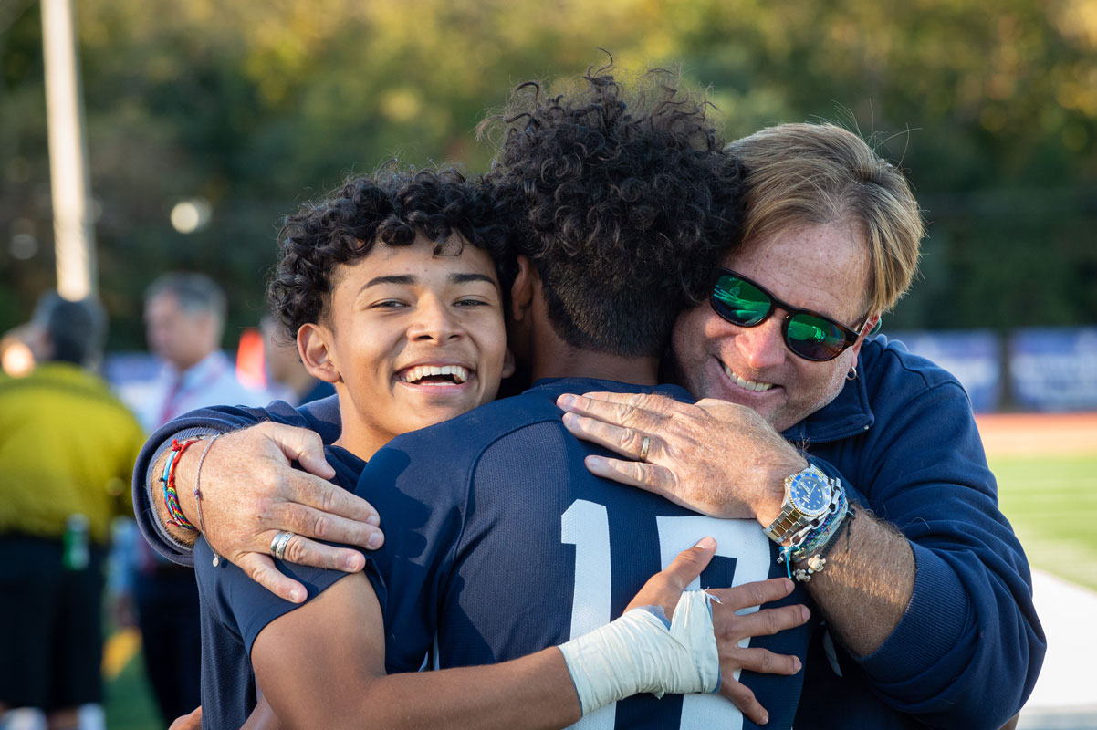 Huntington head coach John Pagano hungs his players after the big win. (Darin Reed photo.)