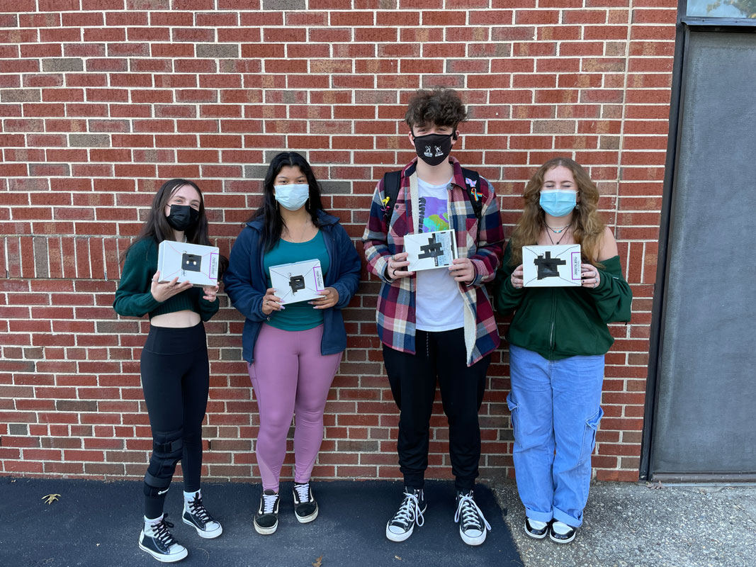 Huntington students hold their pinhole photography cameras outside the building.