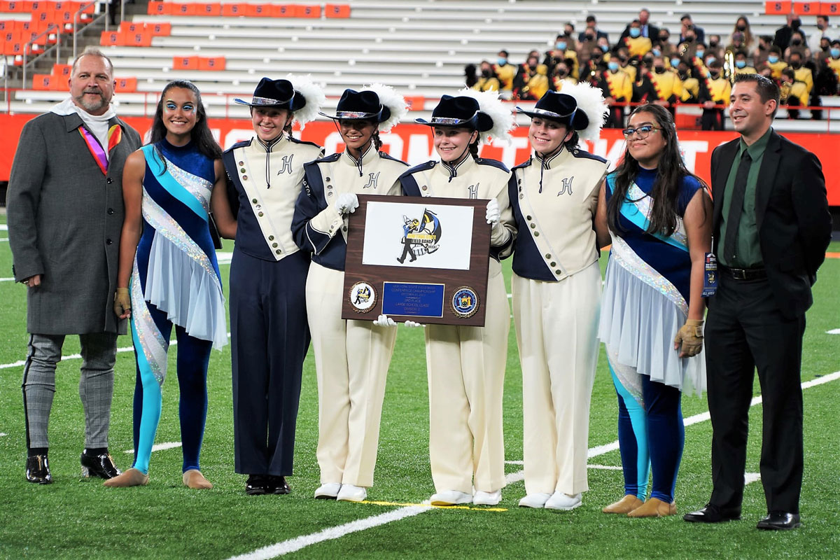Huntington Blue Devil band leaders on the Carrier Dome field with this year's award. (Gregg Geller photo.)