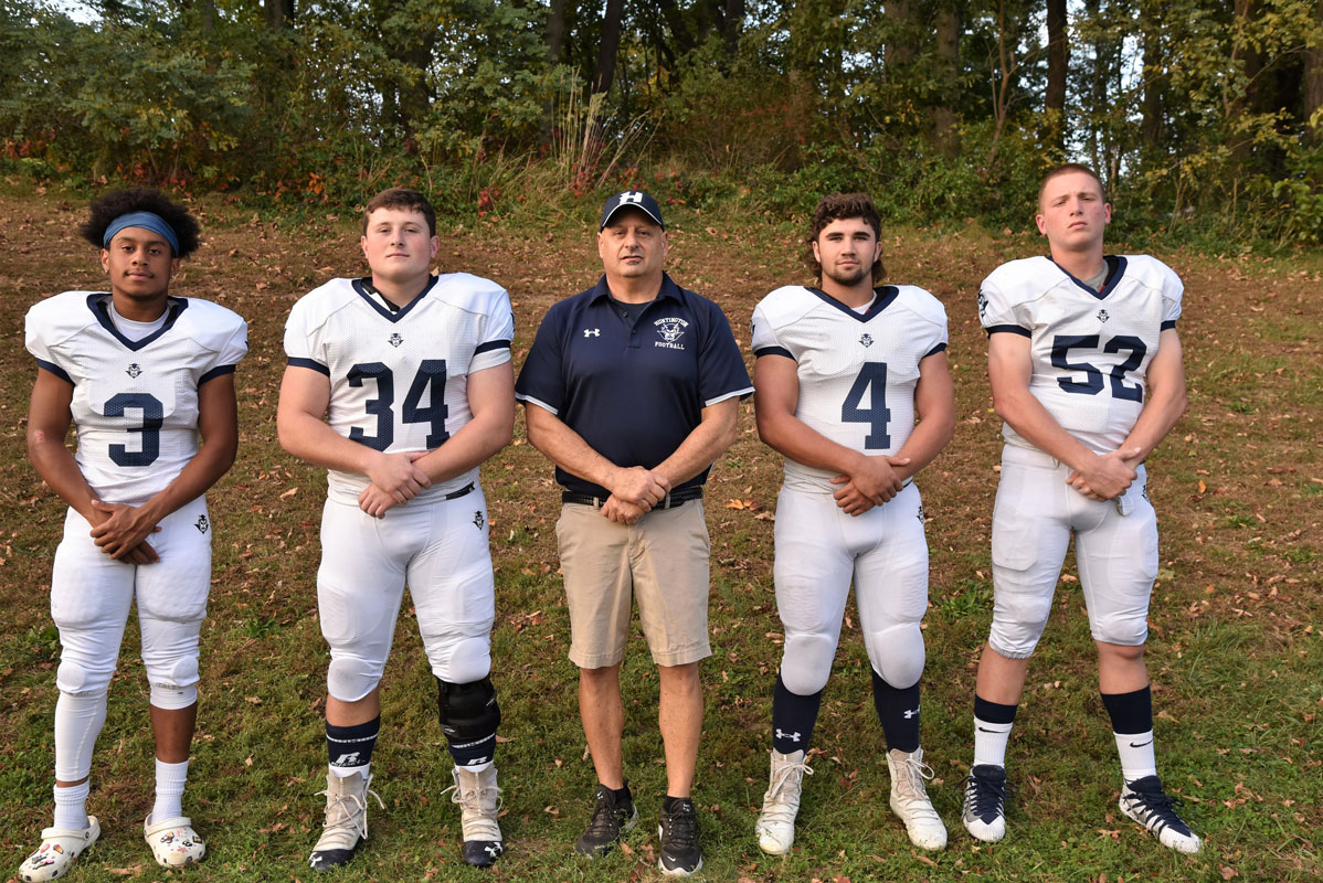 Huntington head coach Steve Muller is flanked by captains Josiah Melendez, Robbie Smith, Lucas Petrizzi and Liam McDonald.