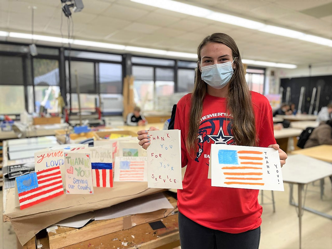 Senior Emily Plachta with Veterans Day cards she created in art teacher Kristin Singer's class.