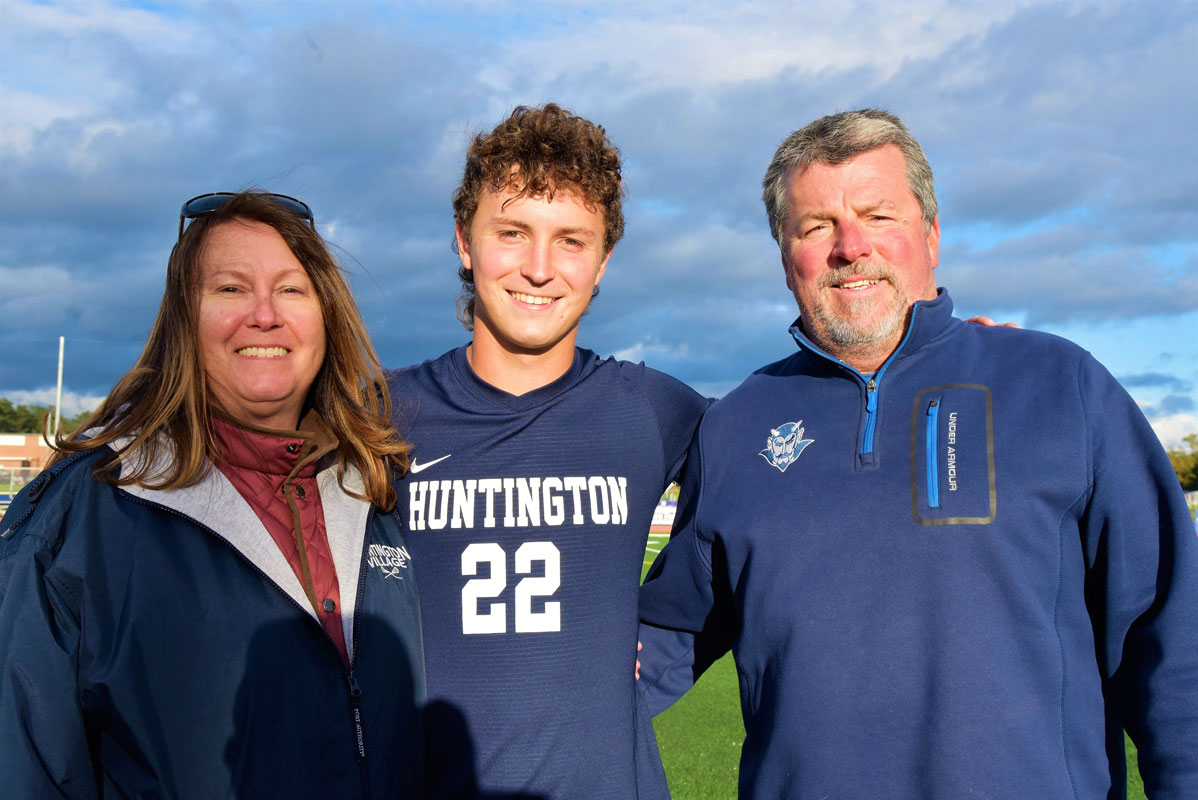 Liam Lennon is flanked by his parents on Huntington boys' soccer Senior Day.