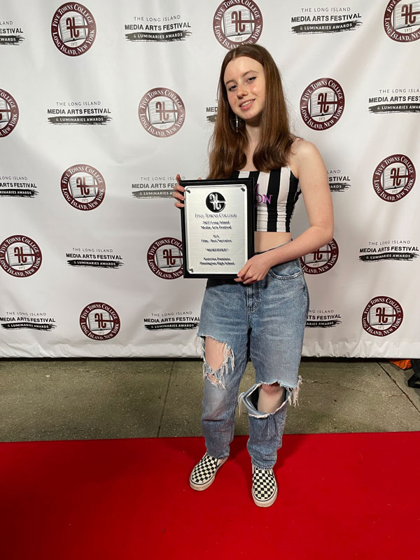 Huntington junior Katerina Damiano holds here award at Five Towns College in Dix Hills.