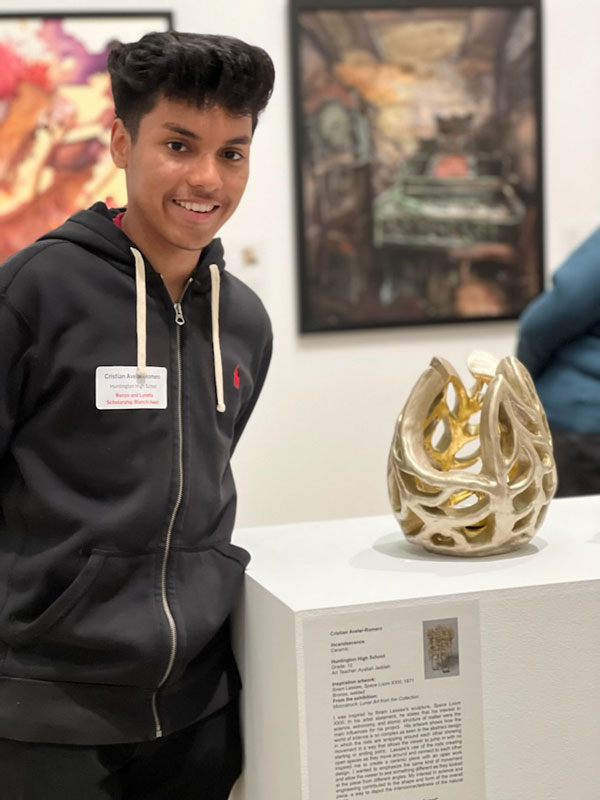 Cristian Avelar-Romero with his sculpture at the Heckscher Museum of Art 