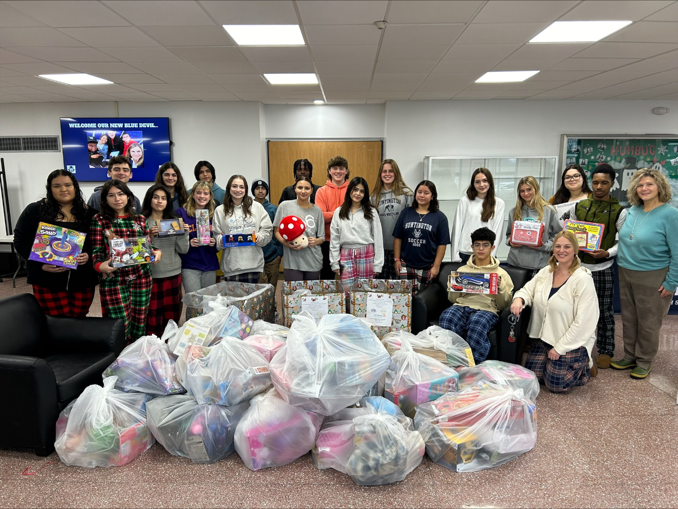 Huntington Key Club members with 200 gifts in the school lobby.  