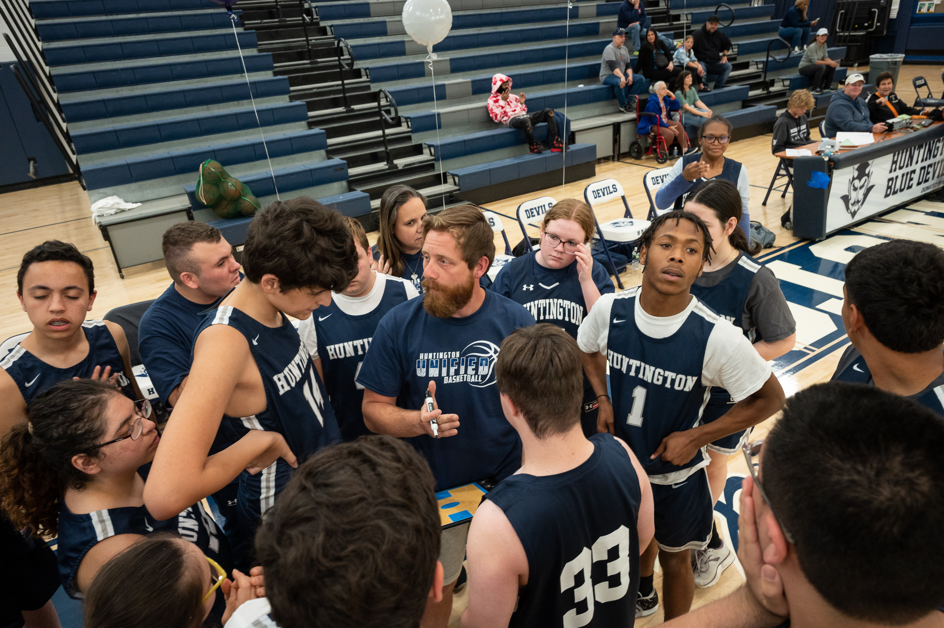 Blue Devil players huddle around head coach Jordan Ioviero. (Darin Reed photo.)