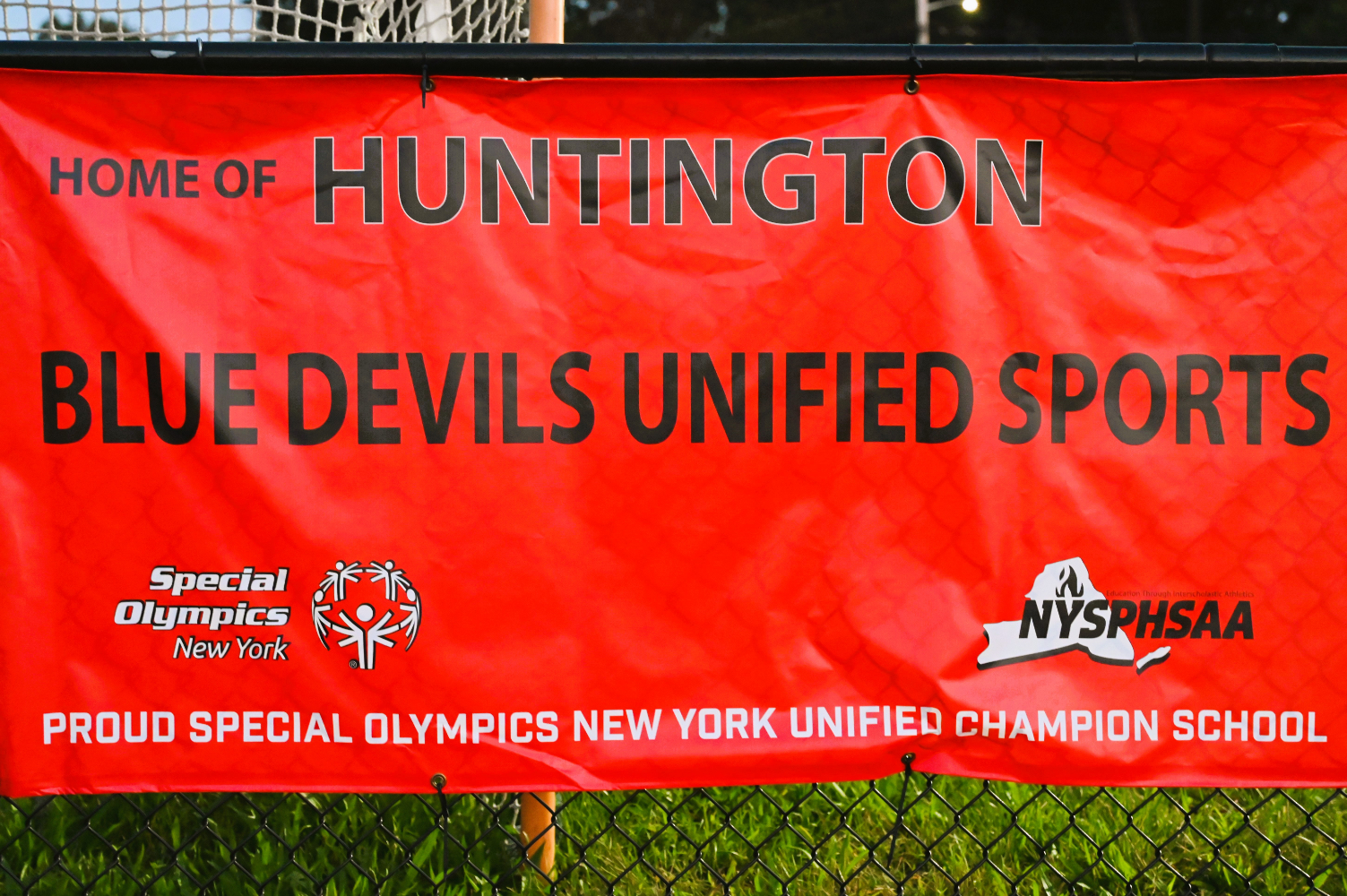  A Unified Sports banner hangs on the fencing circling Blue Devil Stadium.    