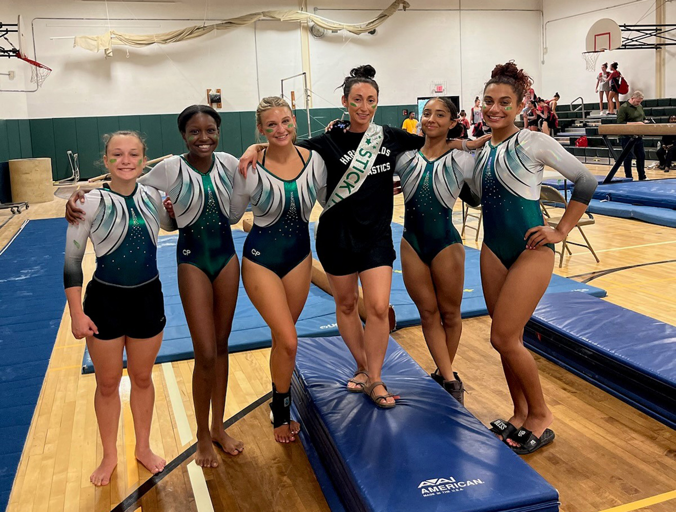  Huntington coach Jackie Lazzarini (in black) is flanked by the Blue Devil gymnasts.  