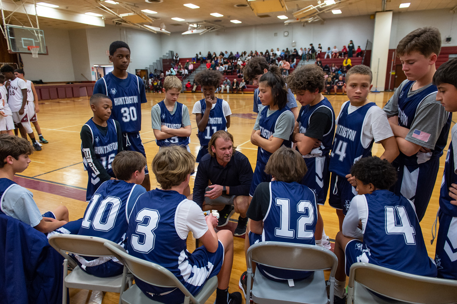  Coach Tim Madden huddles with the team during a timeout. (Darin Reed photo.)  