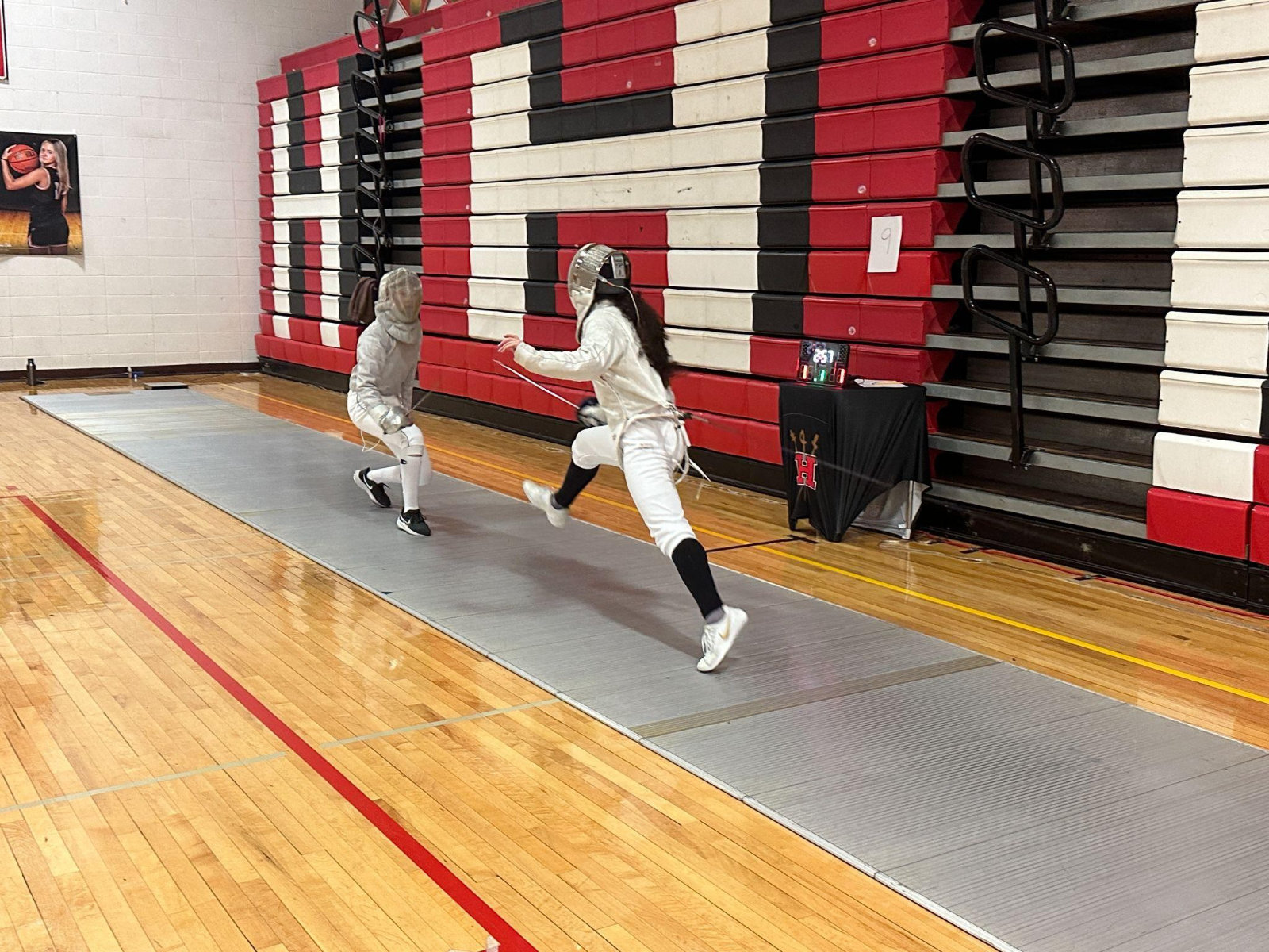  Sophomore sabre fencer Julia Goodwin (right) makes an attack during the second round of pools. 