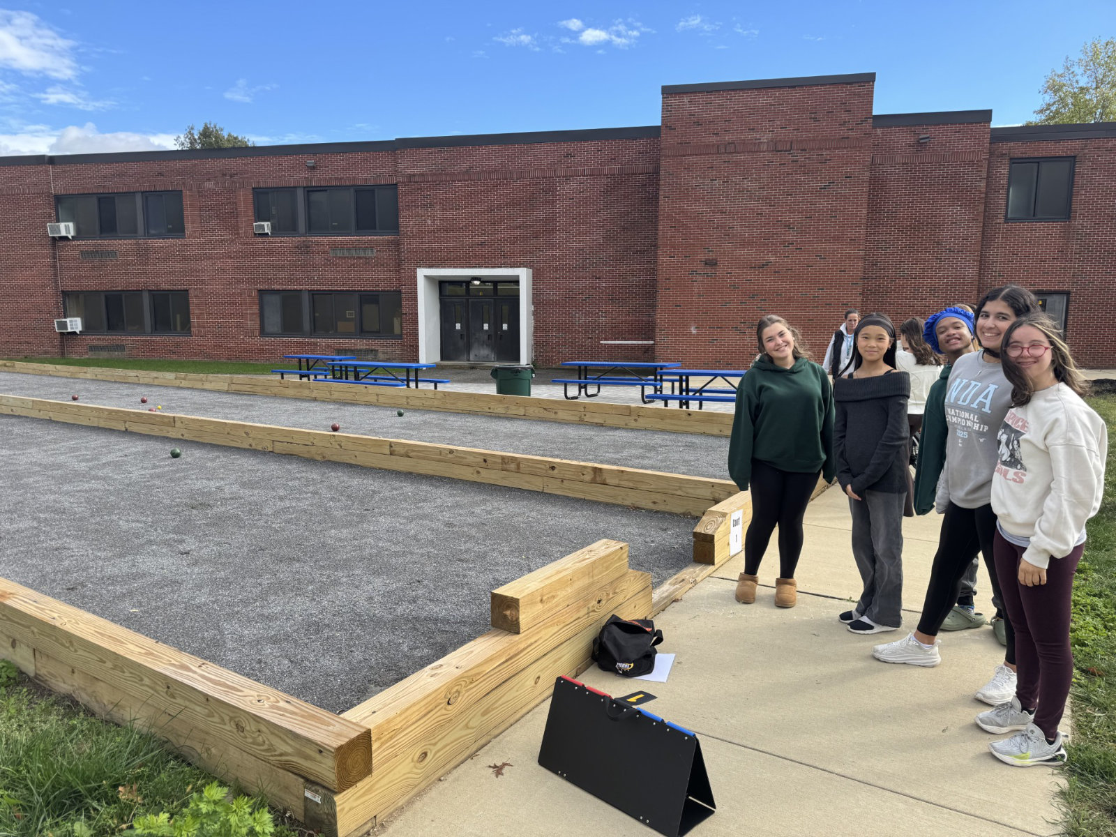  Varsity Unified bocce team members stand near the new courts during the first practice.  